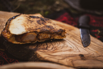 quritto on a wooden board, prepared over a fire in the forest