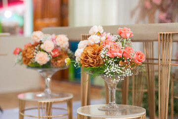 Orange-toned flowers are arranged in clear glass vases for parties or auspicious events.