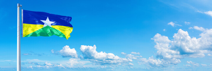 Rond&ocirc;nia - state of Brazil, flag waving on a blue sky in beautiful clouds - Horizontal banner
