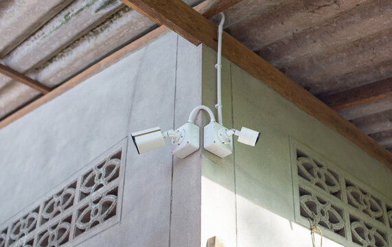 Two CCTV cameras installed in the corner of the house where the cement wall has not yet been painted.
