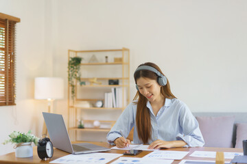 Remote business concept, Businesswoman wear headphone to meeting in video call and taking notes