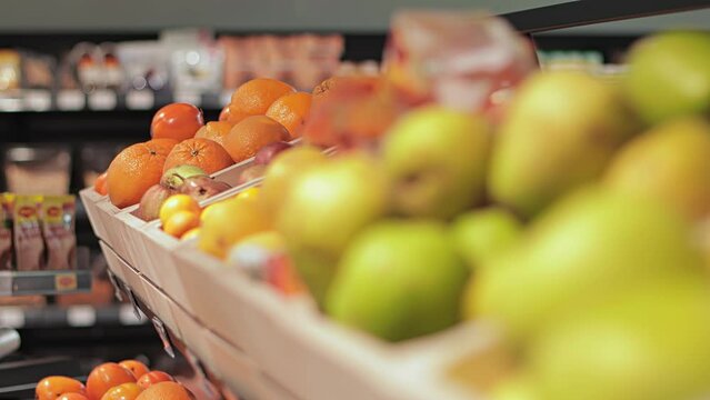 Fresh farm fruits persimmon, oranges, tangerines, green apples are in drawer box on shelf in store shop. Natural organic food. Healthy diet, assortment of vitamins. Agriculture. Modern mall, grocery
