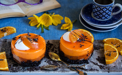orangentorte mit Schokolade, Blumen, Kaffee und einem Buch für eine Kaffeepause