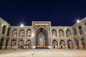 The courtyard of the Sherdor Madrasah is illuminated at night. Registan Square in Samarkand, Uzbekistan