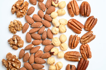 Different delicious nuts on white background, flat lay. Space for text. Nuts background. Top view
