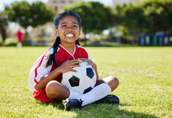 Sports, children and girl soccer player relax on grass with soccer ball, happy and excited at...
