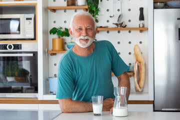 Senior man drinking a glass of milk with a happy face standing and smiling. Handsome senior man...