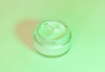 Opened Cosmetic jar close up, mockup. Green light. Everyday skincare routine
