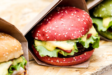Close-up view of hamburger with red buns on wooden background