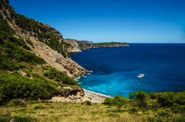 Beautiful scenery of a bay on Mallorca with pure blue water and a yacht.