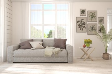 White living room with sofa and summer landscape in window. Scandinavian interior design. 3D illustration