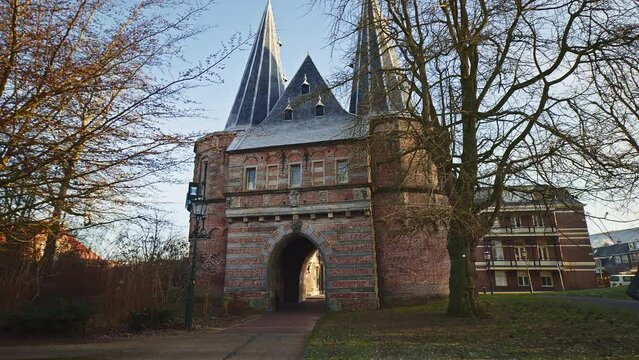 POV walking footage of an empty street in Kampen, the Netherlands, leading to an old city gate.