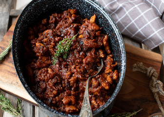 Italian chicken stew with tomatoes, onion, garlic, herbs and red wine in a rustic pot