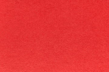 Texture of bright red and ruby colors paper background, macro. Structure of dense craft garnet cardboard.