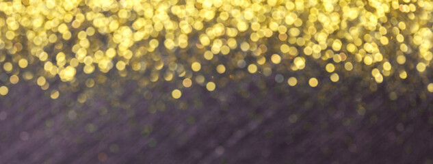 Black blurred background for Christmas greeting card with golden sequins lights bokeh.