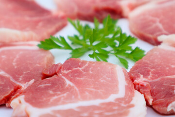 Raw Pork Slice in White Round Plate decorated with parsley. Fresh raw pork.