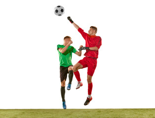 Soccer player and goalkeeper in action, motion on green grass flooring isolated over white background. Sport, championship, competition, football match