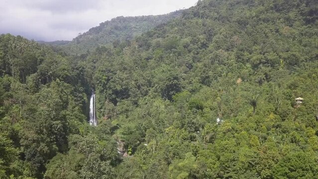 Aerial flight to tall jungle mountain waterfall, North Bali, Indonesia