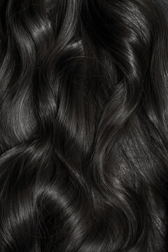 Brunette Or Black Hair. Female Long Dark Hair In Black. Beautifully Laid Curls. Closeup Texture In A Dark Key. Hairdressing, Hair Care And Coloring. Shading Gray Hair. Background With Copy Space.