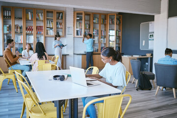 Students, laptop and modern library for education, learning and study on school campus. Men, women or people with technology for homework, university research and scholarship review for future growth