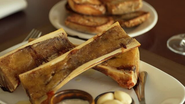 4K tasty food video. Close up view of a dish with beef marrow in its own bone.