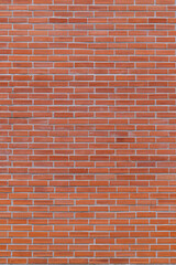 Portrait background of orange brick wall There is a lot of texture detail and bricks.