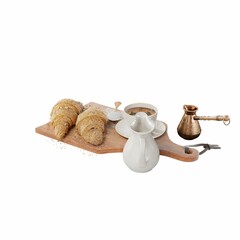 Closeup of delicious croissants, coffee cup, milk jug, cezve and a spoon of sugar on a wooden board