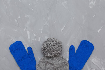 Knitted winter clothes, neatly stacked on a white background. The surface of women's woolen things, textiles. Close-up knitted texture. The background is gray. Casual clothes.