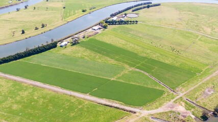 Agricultural, green fields and countryside houses by the riverbed, aerial