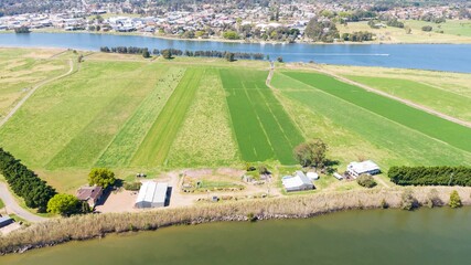 Agricultural, green fields and countryside houses by the riverbed, aerial