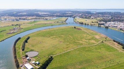 Agricultural, green fields and countryside houses by the riverbed, aerial