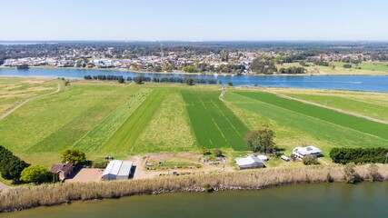Agricultural, green fields and countryside houses by the riverbed, aerial