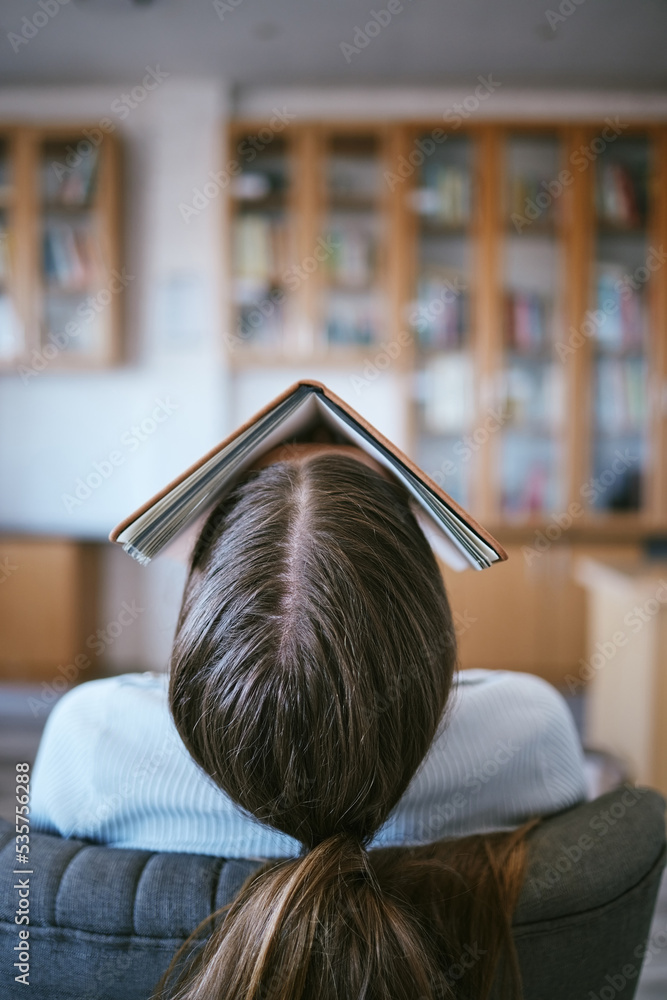 Poster burnout, tired and sleeping student with book on face in university library learning, education or r