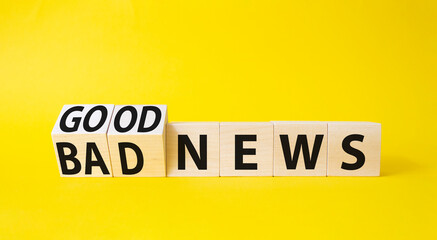 Obraz premium Good news and Bad news symbol. Turned wooden cubes with words Bad news and Good news. Beautiful yellow background. Business concept. Copy space