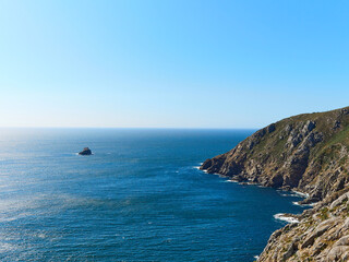 Galician coast, cliff with the water hitting the rocks on a sunny day. Horizontal view