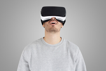Studio portrait of astonished man in virtual reality glasses