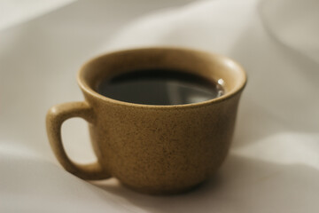 cup of coffee in the morning. espresso coffee. Coffee porridge on a white background
a cup of coffee on a white cloth. sun rays on a cup of coffee