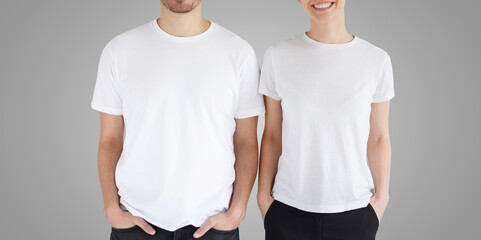 Young smiling couple in blank white t-shirts isolated on gray