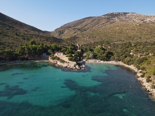 Aerial view of Cala Moresca and Figarolo Island in Golfo Aranci, north Sardinia. Birds eye from above of yacht, boats, crystalline and turquoise water. Tavolara Island in the background, Sardegna.