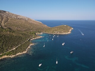Aerial view of Cala Moresca and Figarolo Island in Golfo Aranci, north Sardinia. Birds eye from above of yacht, boats, crystalline and turquoise water. Tavolara Island in the background, Sardegna.