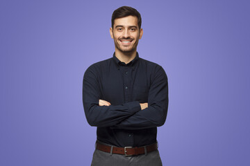 Modern businessman in black shirt standing with crossed arms on purple background