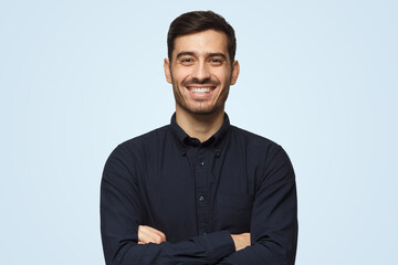Attractive smiling business man in black shirt isolated on blue background