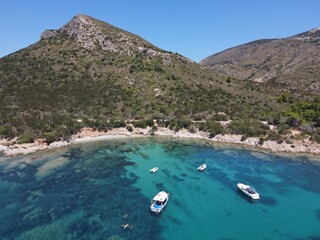 Obraz premium Aerial view of Cala Moresca and Figarolo Island in Golfo Aranci, north Sardinia. Birds eye from above of yacht, boats, crystalline and turquoise water. Tavolara Island in the background, Sardegna.