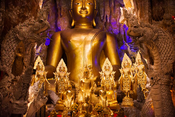 Golden buddha image statue and naga guardian of Wat Maniwong for thai people travel visit tunnel...