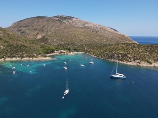 Obraz premium Aerial view of Cala Moresca and Figarolo Island in Golfo Aranci, north Sardinia. Birds eye from above of yacht, boats, crystalline and turquoise water. Tavolara Island in the background, Sardegna.