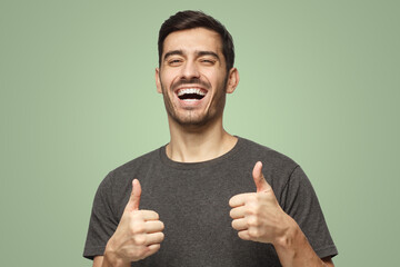 Motivated excited smiling man making thumbs up gesture of approval and success