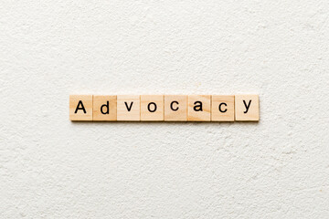 ADVOCACY word written on wood block. ADVOCACY text on cement table for your desing, concept