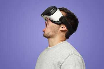 Shocked screaming man watching horror movie through VR glasses