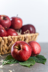 Ripe apple fruit in basket on stone table, front view, white background with copy space. Selective focus on the front