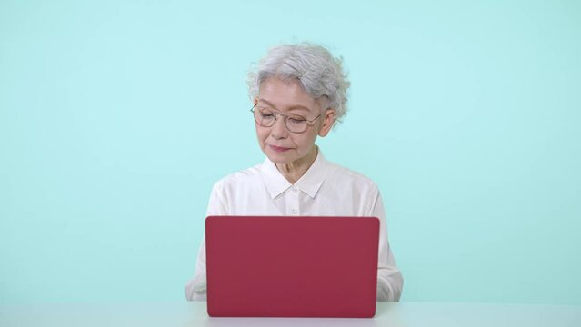 ノートパソコンを使うシニア女性